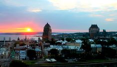 the sun is setting over a city with tall buildings