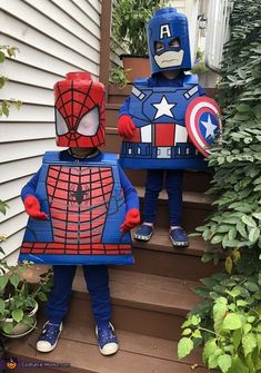 two children dressed up as superheros standing on the steps in front of a house