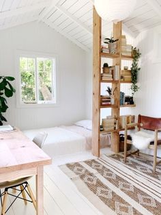 a room with two beds, a desk and a ladder in the wall next to it