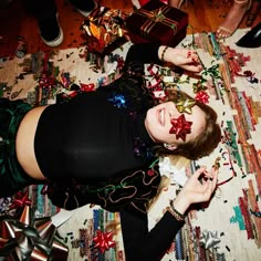 a woman laying on top of a rug covered in confetti