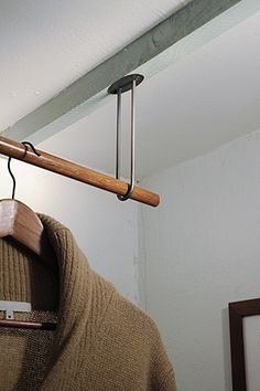 a wooden coat hanger with clothes hanging from it