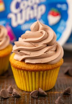 two cupcakes with frosting sitting on a table