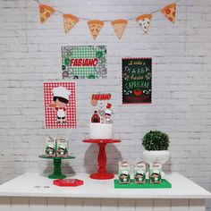 a white table topped with cakes and pizza signs