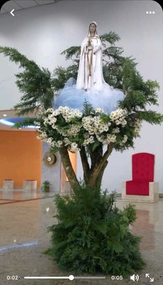 the statue is surrounded by white flowers and greenery