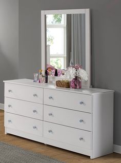 a white dresser and mirror in a room