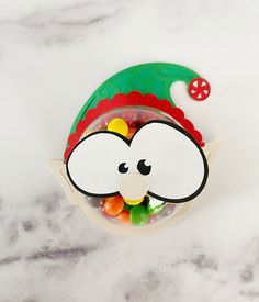 a bowl filled with gummy bears sitting on top of a marble counter next to a candy dispenser