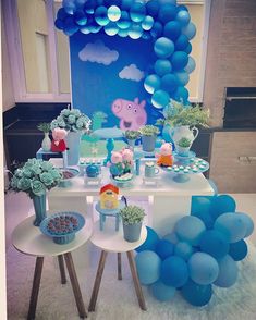 a table set up with balloons, cake and decorations for a peppa pig birthday party