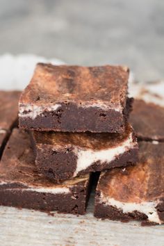 some brownies are stacked on top of each other and have white frosting in them