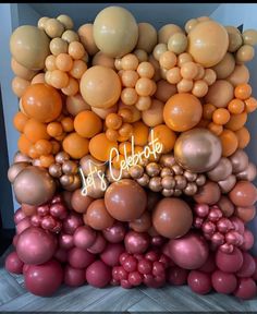 an assortment of balloons are arranged in the shape of a giant orange and gold balloon