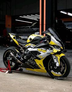 a yellow and black motorcycle parked in front of a building