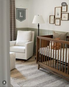 a baby's room with a crib, chair and pictures on the wall