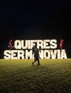 two people standing in front of a sign that says quefres sermnovaa