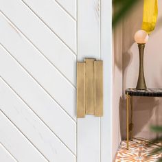 a white door with a gold handle and a yellow light on it's side