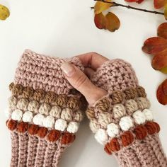 someone is holding their hands up to knitted mitts