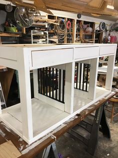 a white cabinet with black bars on the front and sides is being worked on in a shop