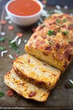 two slices of bread with meat and cheese on them next to a bowl of sauce