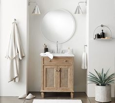 a bathroom with a sink, mirror and towel rack on the wall next to it