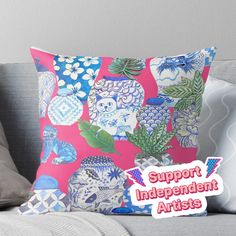 a pink pillow with blue and white flowers on it that says support independent artists throw pillow