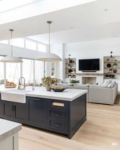 a large kitchen with an island in the middle and lots of windows on both sides