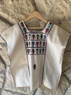 Introducing our Oaxacan Muñequitos Blouse, hand-embroidered in Amuzgos, Oaxaca. Each blouse is a work of art, featuring rows of beautifully handcrafted muñequitos on the front and a lone little doll on the back. Made from organic cotton and cotton thread, this blouse is as comfortable as it is unique. Measurements 51" full bust 26" length  Fabric care: handwashing and line dry in indirect sun Fabric gets softer after every washing.  no refunds and exchanges are available within thirty days of pu Womens Blouses, San Antonio Tx, Cotton Thread, San Antonio, Etsy Finds, Womens Clothing Tops, Fabric Care, Hand Embroidered, Back To School