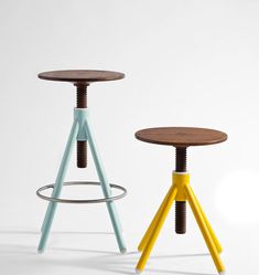 two stools with different colored legs and wood top, one on the other side