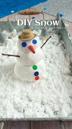 a snowman made out of buttons in a metal pan