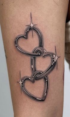 a black and white tattoo on the leg of a woman with two hearts attached to it