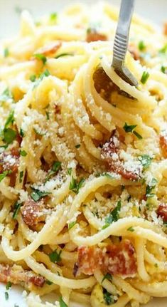 a fork is stuck into some pasta with parmesan cheese