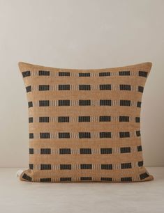 a brown and black pillow on a white surface