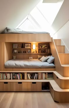 a loft bed with built in bookshelves and stairs leading up to the bedroom