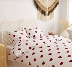 a white bed with red hearts on it