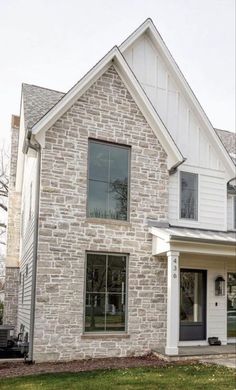 a white brick house with two story windows