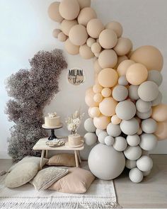 a room filled with lots of balloons and cake on top of a wooden table next to a white wall