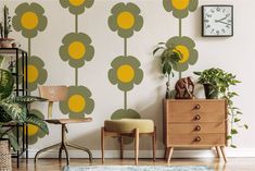 a living room with a flower wall decal on the wall next to two chairs