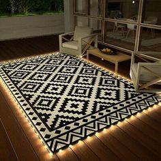 a black and white area rug with lights on the floor in front of a window