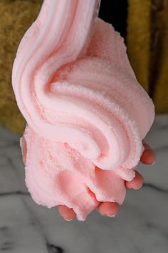 a person holding up a pink ice cream