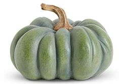 a green pumpkin sitting on top of a white table