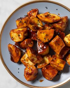 a white plate topped with fried potatoes covered in sauce