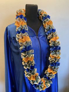 a blue graduation gown with ruffles and dollar bills on the front, along with a black mannequin headdress