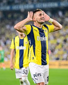 a soccer player is holding his head in the air