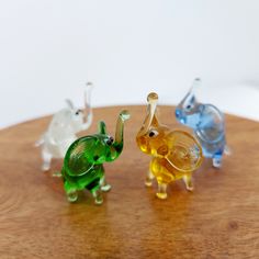 three glass elephants sitting on top of a wooden table