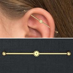 an ear piercing with a red stone in the middle and a gold bar attached to it