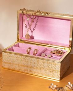 an open jewelry box sitting on top of a wooden table next to a necklace and earrings