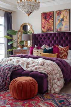 a purple bed with lots of pillows on top of it and a chandelier hanging from the ceiling