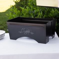 the table is set with plates and napkins for an elegant wedding reception in black