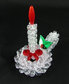 a glass candle holder with red and green decorations