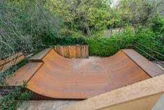 a skateboard ramp in the middle of a wooded area