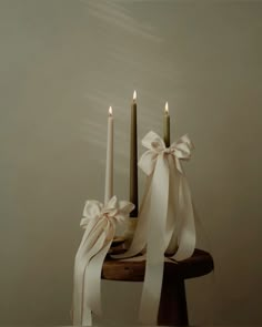 two candles with white ribbons tied around them