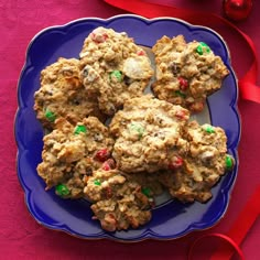 cookies on a blue plate with green and pink sprinkles next to red ribbon