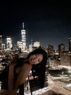 a woman standing on top of a tall building in front of a cityscape